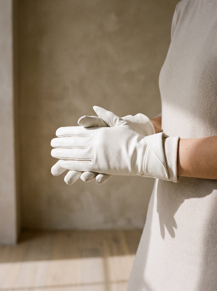 The Hetty Glove in White, worn on both hands, held at waist height