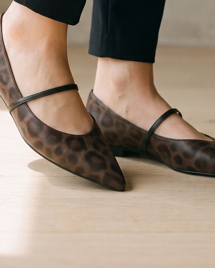 Pointed flats in a brown animal print, worn