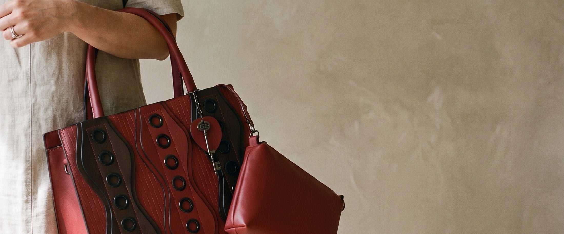 A burgundy tote with a matching pouch, carried